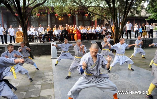 Sri Lankan Prime Minister D.M. Jayaratne (C, rear) watches monks performing Chinese Kungfu in the Shaolin Temple located on Songshan Mountain in central China&apos;s Henan Province, July 20, 2010. Jayaratne visited the world-renowned Shaolin Temple on Tuesday. The 1,500-year-old temple is regarded as one of the holy sites of Chinese Kungfu. [Zhu Xiang/Xinhua]