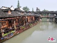 Wuzhen as part of Tongxiang in northern Zhejiang Province, lies within the triangle formed by Hangzhou, Suzhou and Shanghai. It displays thousands of years of history in its ancient stone bridges floating on mild water, its stone pathways between the mottled walls and its delicate wood carvings. Also, it gives a unique experience through its profound cultural background, setting it apart from other towns. [Photo by Xiaoyong]