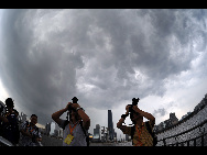 Reporters take photos of the clouds covering Guangzhou City in south China's Guangdong Province, July 21, 2010 [Xinhua]