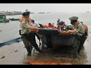 Armed Police help the fishermen to pull the fishing boats out of the water in Shenzhen City, south China's Guangdong Province, July 21, 2010. [Xinhua]