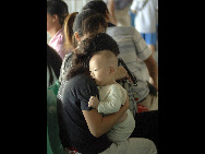 Passengers wait at Xiuying Port as the transportation services currently stops across the Qiongzhou Straits, in south China's Hainan Province, July 21, 2010.  [Xinhua]