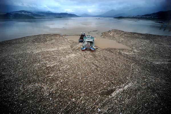 Clean-up vessels clear debris and runoff from flooding near the Three Gorges Dam to ensure proper future flood discharge in Yichang of central China&apos;s Hubei province, on July 21. A large amount of debris was carried by floods near the Three Gorges Dam, which could block the flood discharge channels. Numerous vessels were dispatched to clear away the debris around the clock. [Xinhua]
