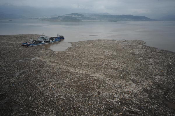 Clean-up vessels clear debris and runoff from flooding near the Three Gorges Dam to ensure proper future flood discharge in Yichang of central China&apos;s Hubei province, on July 21. A large amount of debris was carried by floods near the Three Gorges Dam, which could block the flood discharge channels. Numerous vessels were dispatched to clear away the debris around the clock. [Xinhua]