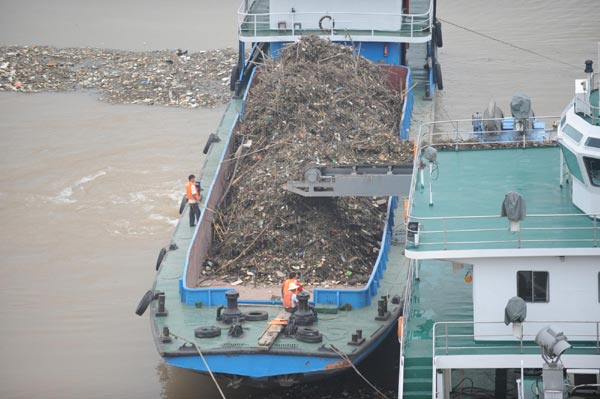 Clean-up vessels clear debris and runoff from flooding near the Three Gorges Dam to ensure proper future flood discharge in Yichang of central China&apos;s Hubei province, on July 21. A large amount of debris was carried by floods near the Three Gorges Dam, which could block the flood discharge channels. Numerous vessels were dispatched to clear away the debris around the clock. [Xinhua]