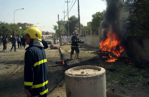 Iraqi firemen rush to the scene of an attack in the northern oil hub of Kirkuk after a suicide attacker in a car set off a bomb outside a government building, wounding nine people including an official responsible for religious properties, according to police on July 4, 2010.[yeeyan.org]