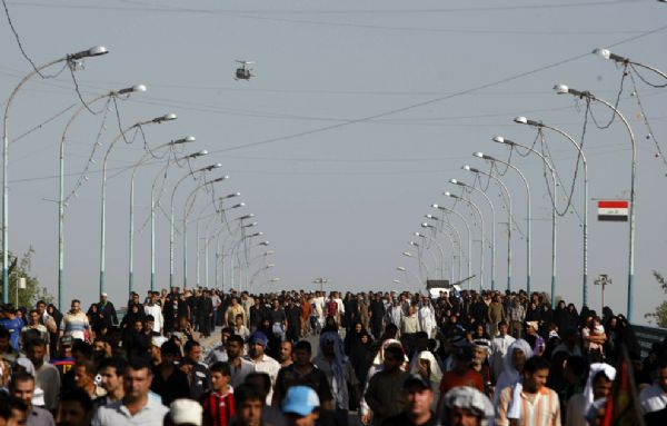 Shi&apos;ite Muslim pilgrims walk across a bridge from the Sunni district of Adhamiyah towards Kadhimiyah, an area named after Imam Musa Kadhim, the seventh of 12 revered imams in Shiite Islam, whom the pilgrims are honoring, on July 8, 2010, a day after a suicide bomber wearing an explosives-filled belt targeted Shiite pilgrims crossing through Adhamiyah and murdered 28 people.[yeeyan.org]