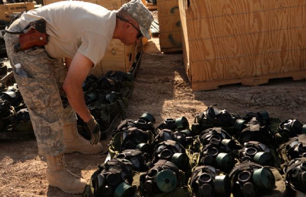 A U.S. Army soldier from the 49th Military Police Brigade counts gas masks as the unit prepares to ship their equipment and belongings home Sunday, July 18, 2010 at Camp Victory in Baghdad, Iraq.[yeeyan.org]