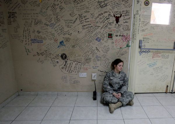 U.S. Air Force medical technician Rachel Reidel pauses in &apos;Heroes Hall,&apos; on May 8, 2010, a place where injured service members were encouraged to pay tribute to fallen comrades while waiting to be evacuated to Germany, at the Air Force Theater Hospital at Joint Base Balad, Iraq. [yeeyan.org]