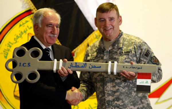 U.S. Major General Jerry Cannon dedicates a giant key to Iraq&apos;s Justice Minister Dara Noor-Eldeen as a symbolic gesture during a ceremony marking the transfer of Camp Cropper, the last U.S. detention center in Iraq, to the Iraqi government in Baghdad July 15, 2010. [yeeyan.org]