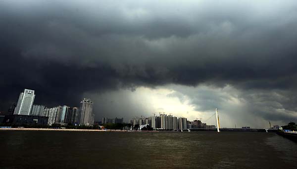 Thick clouds hang over Guangzhou city, South China's Guangdong province, July 21, 2010. Southern China is bracing for its second powerful storm in less than a week as the typhoon Chanthu is expected to make landfall in Guangdong and Hainan provinces on Thursday. [Xinhua]