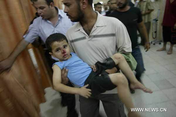 A wounded Palestinian boy is carried into Beit Hanoun hospital, northern Gaza Strip, July 21, 2010. At least one Palestinian militant was killed and about seven others were wounded Wednesday afternoon in an Israeli artillery shelling in northern Gaza Strip town of Beit Hanoun, witnesses and ambulance officials said. [Xinhua]