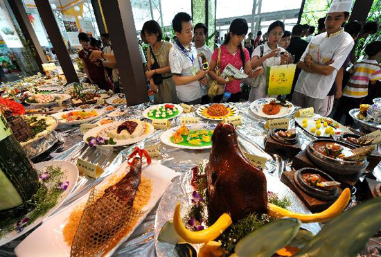 Visitors look around at a food cultural festival held in Nanjing, capital of east China's Jiangsu Province, July 21, 2010. The festival which opened here on Thursday includes a series of activities, such as exhibition of food culture, cultural exchange of old-branded restaurants and painting and calligraphy creation on food, etc. [Xinhua photo]