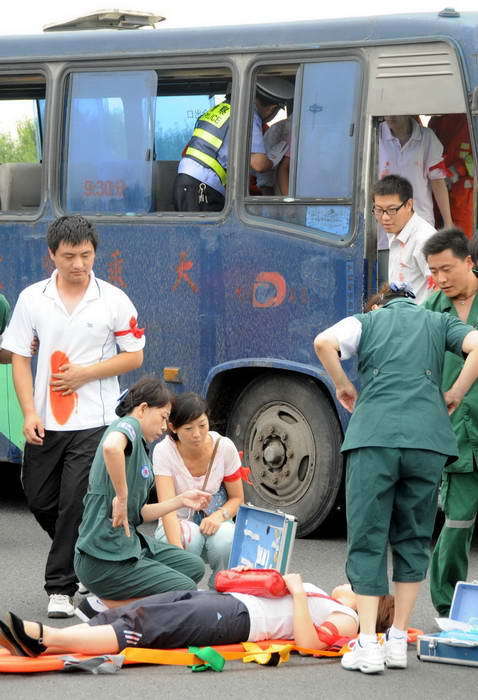 Medical workers prepare to give emergency treatment to the wounded after a simulated bridge collapse during a rescue drill on the Shenyang-Dalian highway in Northeast China&apos;s Liaoning Province, July 22, 2010. [Xinhua]