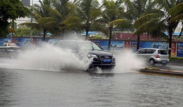 A car runs on a flooded road in Haikou, capital of South China&apos;s Hainan province, after Typhoon Chanthu hits the island Thursday, July 22, 2010. [Xinhua]