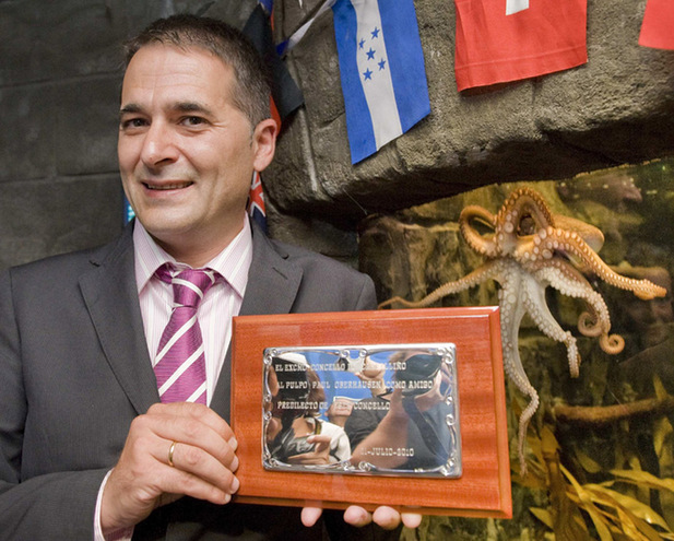 Carlos Alberto Montes Marques, mayor of the Spanish town Carballino presents an award to &apos;Paul&apos;, the so-called &apos;octopus oracle&apos; at the Sea Life Aquarium in the western German city of Oberhausen July 22, 2010. The award nominates Paul as the &apos;favorite friend of the town&apos;.[Xinhua/Reuters]