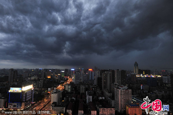 Dark clouds cover the sky and cast a gloom over the Yangtze River in Wuhan, Central China&apos;s Hubei province July 22, 2010. [CFP]