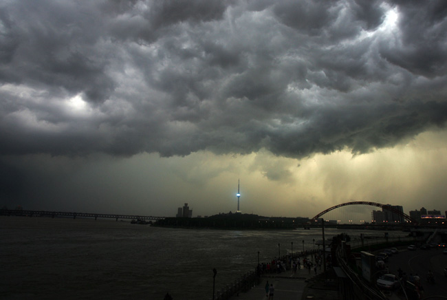 Dark clouds cover the sky and cast a gloom over the Yangtze River in Wuhan, Central China&apos;s Hubei province July 22, 2010. [Xinhua]