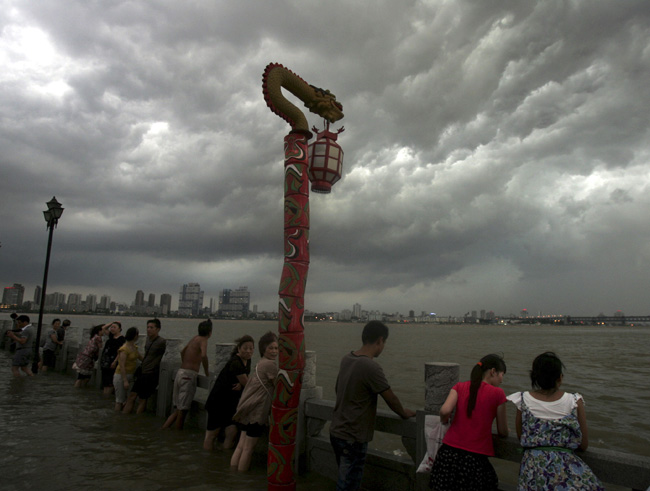 People watch the Yangtze River as dark clouds pass overhead July 22, 2010, in Wuhan, Central China&apos;s Hubei province. Spectators were waiting for the next round of flood crests which arrived on Thursday night. [Xinhua]