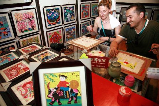 Foreign visitors learn to draw rural paintings in Fengjing Township in east China's Shanghai, July 22, 2010. [Xinhua photo]