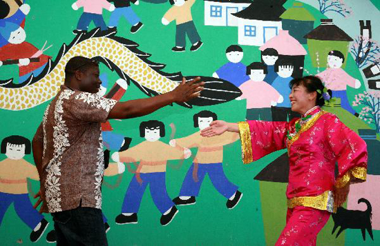 A foreign visitor learns local dance from a villager in Fengjing Township in east China's Shanghai, July 22, 2010. [Xinhua photo]