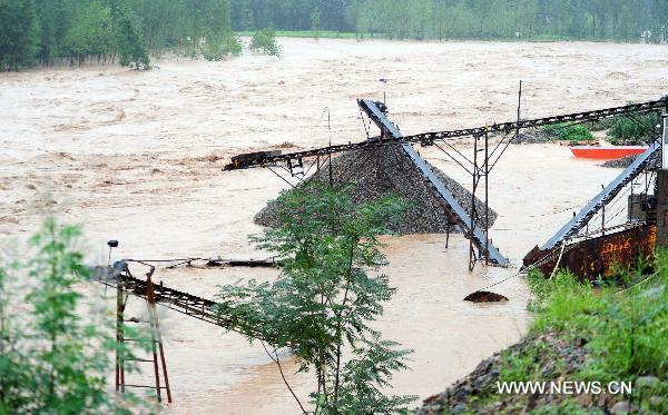 Photo taken on July 24, 2010 shows a flooded sand quarry along the Yi River in Song County, central China's Henan Province. A heavy rainstorm hit the Yuxi mountain area in Henan Province from Friday to Saturday. Rain-triggered floods have killed four people and left two missing in Luanchuan County. Communication was also interrupted in some areas of Henan. (Xinhua/Gao Shanyue)