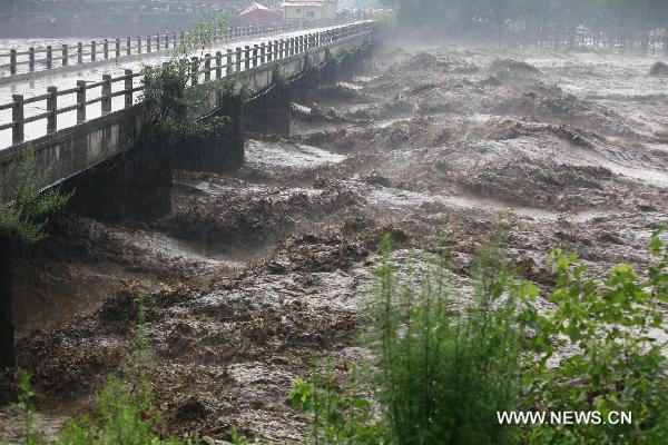 Photo taken on July 24, 2010 shows a bridge in the flooded Yi River in Jiuxian Village in Song County, central China's Henan Province. A heavy rainstorm hit the Yuxi mountain area in Henan Province from Friday to Saturday. Rain-triggered floods have killed four people and left two missing in Luanchuan County. Communication was also interrupted in some areas of Henan. (Xinhua/Zhang Xiaoli)