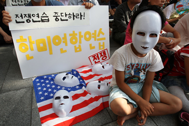 A boy attends the rally against South Korea and US&apos; joint military drills in Seoul, capital of South Korea, July 25, 2010. South Korea and the United States began their large-scale joint navy drills off the east coast of the Korean Peninsula on Sunday. [Xinhua]