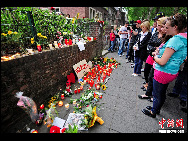 Candles and a flowers are placed by residents on their window-sill in the neighbourhood where a stampede took place in Duisburg July 25, 2010. [Chinanews.com.cn]