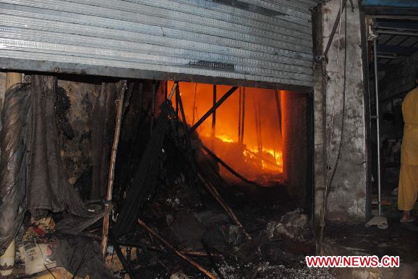 Fire rages in a shop after two blasts in a local market in southwest Pakistan's Quetta on July 25, 2010. Over 100 shops caught fire following two gas cylinder explosions which occurred late Sunday night in Quetta. [Iqbal Hussain/Xinhua]