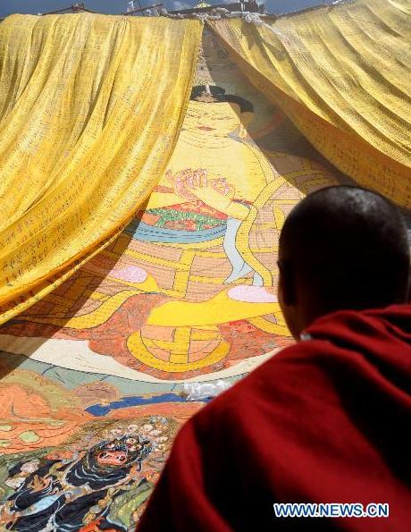 A monk looks at the thangka during the annual thangka unfurling ceremony at Ganden Monastery in Lhasa, capital of southwest China's Tibet Autonomous Region, July 25, 2010.