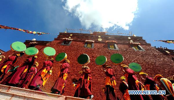 Monks perform religious ritual during the annual thangka unfurling ceremony at Ganden Monastery in Lhasa, capital of southwest China's Tibet Autonomous Region, July 25, 2010. [Gesang Dawa/Xinhua]