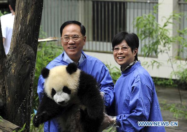 Donald Tsang Yam-Kuen, Chief Executive of China's Hong Kong Special Administrative Region, and his wife visit Bifeng Gorge Base of China Conservation and Research Center for the Giant Panda, located in southwest China's Sichuan Province, on July 25, 2010.