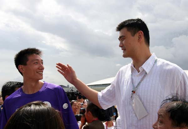 Yao Ming talks to a member of the Shanghai Sharks, Yao&apos;s Shanghai-based basketball team in the Chinese Basketball Association (CBA), during his visit to the Saudi Aribia Pavilion at the Shanghai World Expo, July 25, 2010. [Xinhua] 