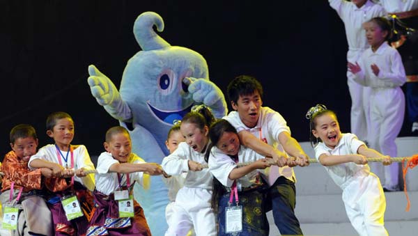 Children from quake-hit areas of Southwestern Wenchuan and Northwestern Yushu take part in a tug-of-war competition during a fund raising party at Shanghai World Expo, July 25, 2010. [Xinhua]