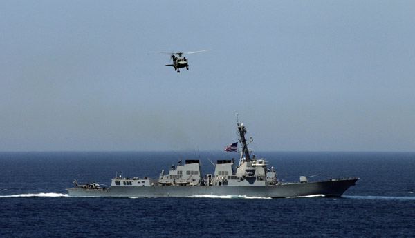 A U.S. Navy helicopter flies over a U.S. warship as they participate in joint military exercises between the U.S. and South Korea in waters off the east coast of the Korean peninsula, July 26, 2010.[Xinhua/Reuters]