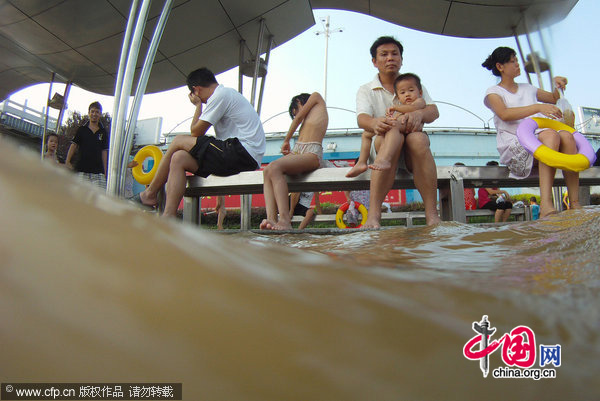 Residents enjoy the flooded waters in Wuhan, Central China&apos;s Hubei province, July 26, 2010. [CFP]