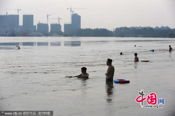 Residents enjoy the flooded waters in Wuhan, Central China&apos;s Hubei province, July 26, 2010. [CFP]