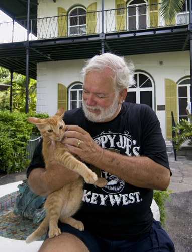 Charles Bicht of Vero Beach caresses a cat at the Ernest Hemingway Home and Museum in Key West, Florida July 25, 2010.[Xinhua/Reuters]