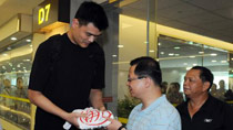 Chinese basketball star and Houston Rockets center Yao Ming gives an autographed jersey as a gift to Taoyuan County executive Wu Chih-Yang at Taoyuan Airport in Taipei, southeast China's Taiwan, July 26, 2010.