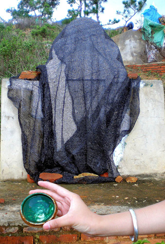 A cap from a paint container is found near a tombstone in Yiliang county of Southwest China&apos;s Yunnan province, July 22, 2010. [Xinhua]