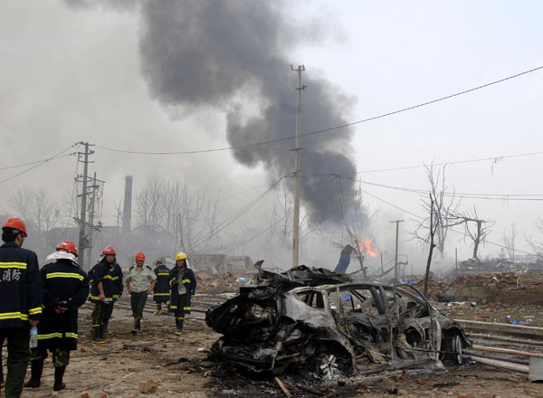 A sedan is totally burned out by the blaze caused by an explosion at a plastics factory in Qixia district of northern Nanjing, capital of East China&apos;s Jiangsu province, July 28, 2010. [Xinhua]