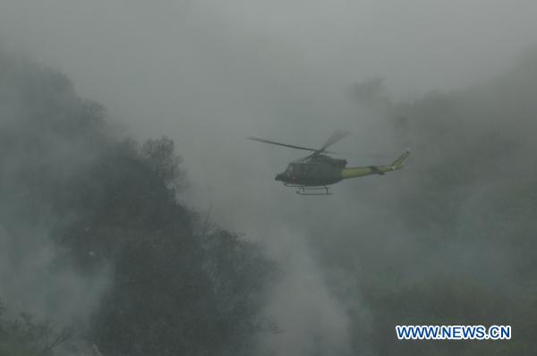 A helicopter files over the site after a jetliner crashed near Islamabad, capital of Pakistan, July 28, 2010. [Zeeshan iyazi/Xinhua]