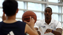 NBA's Orlando Magic center Dwight Howard teaches the skills of passing the ball during a training session in Taipei, southeast China's Taiwan, July 27, 2010.