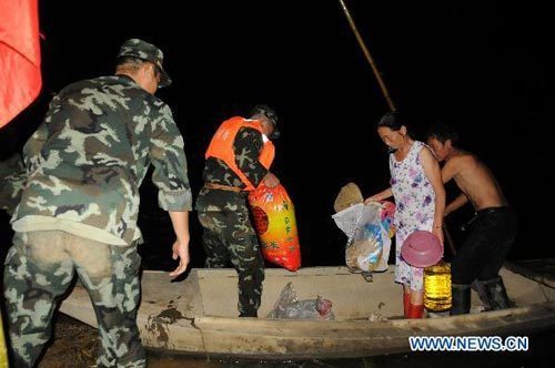 Soldiers evacuate the local residents trapped by flood water in Xiantao, central China's Hubei Province, July 28, 2010. 
