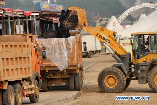 Machines work during the oil spill cleanup operation at the seashore near the development zone in Dalian, northeast China&apos;s Liaoning Province, July 26, 2010. The key work of the oil spill cleanup operation has turned to seashore since Monday. An explosion hit an oil pipeline on July 16 and triggered an adjacent smaller pipeline to explode near Dalian Xingang Port. Both pipelines are owned by China&apos;s No.1 oil and gas producer CNPC.