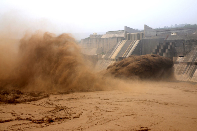 Floodwater rushes through the sluice gates of the Yellow River Xiaolangdi Dam in Luoyang, Henan province on July 27, 2010. The reservoir&apos;s inflow rose up to 1,500 cubic meters a second. [Photo: Xinhua]