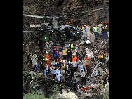 Rescue workers and resident volunteers go through the wreckage of an Airblue passenger plane which crashed in Islamabad's Margalla Hills July 28, 2010. [Xinhua]