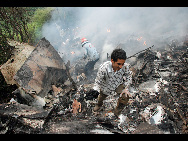 Rescue workers search the wreckage at the site of the crash of an Airblue passenger plane on the outskirts of Islamabad July 28, 2010. [Xinhua]