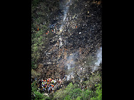 Smoke rises from the wreckage of a passenger plane which has crashed in the Margalla Hills as a helicopter flies over it on the outskirts of Islamabad July 28, 2010. [Xinhua]