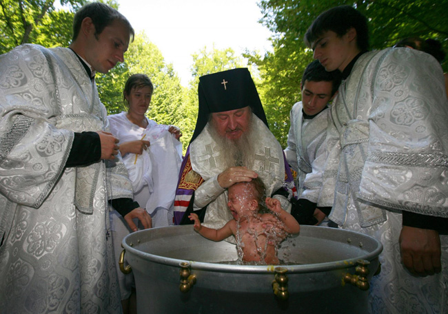 An orthodox priest consecrates water from the Chulym river during a ceremony marking adoption of Christianity, outside Nazarovo town, some 200 km (124 miles) west of the Siberian city of Krasnoyarsk, July 28, 2010. Russia officially celebrated a new holiday on Wednesday marking its conversion to Christianity in 988, the latest Kremlin boost to an Orthodox Church that has grown increasingly powerful since the fall of Communism. [Photo/Agencies]